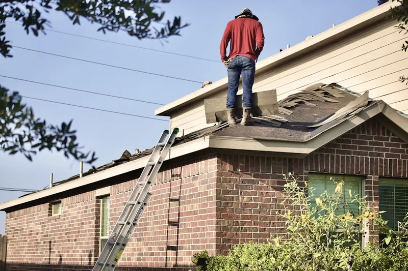 Professional roofer working on a residential roof in Kent Park